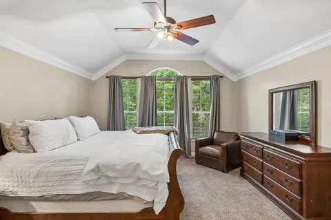 a bedroom with a bed and a large window