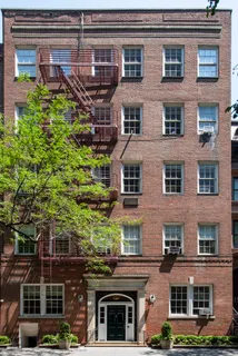 a front view of a building with a garden and plants
