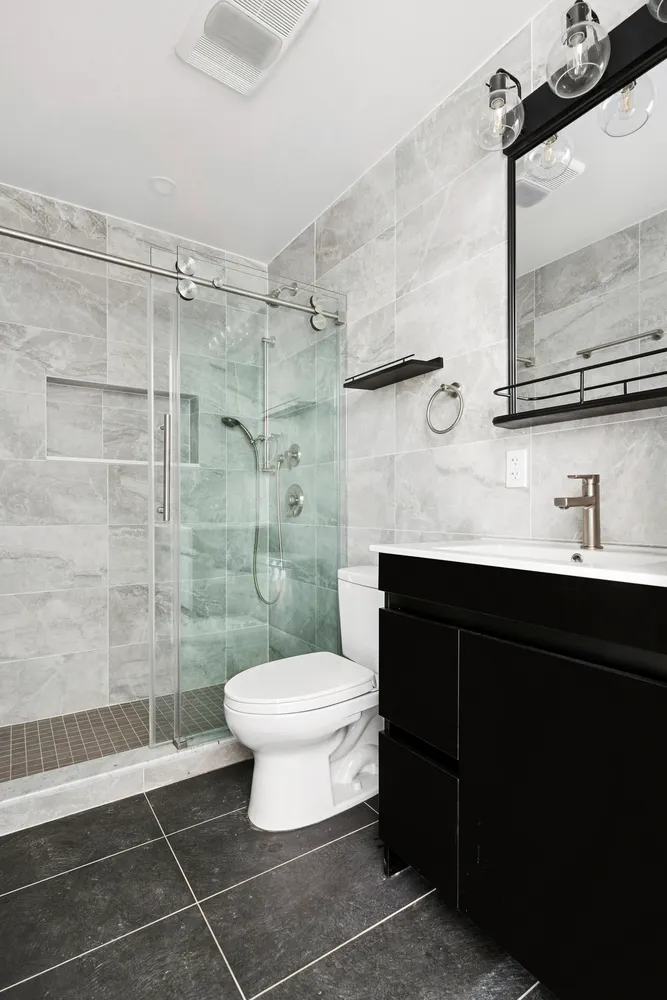 a bathroom with a sink toilet a mirror and shower