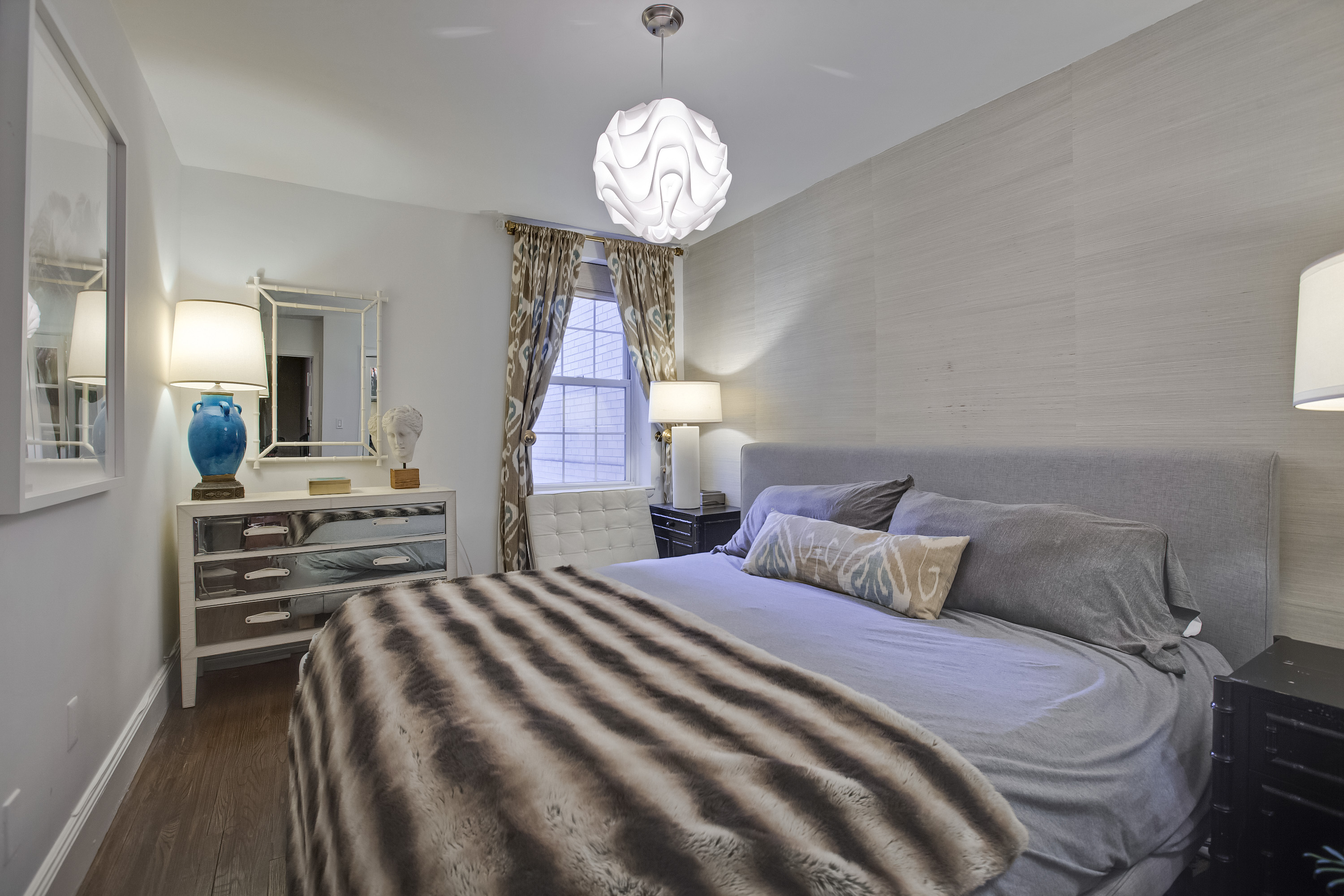 1396 3rd Avenue, Unit 1B Manhattan, NY 10075 - Photo 4 of 7 a bedroom with bed and a chandelier