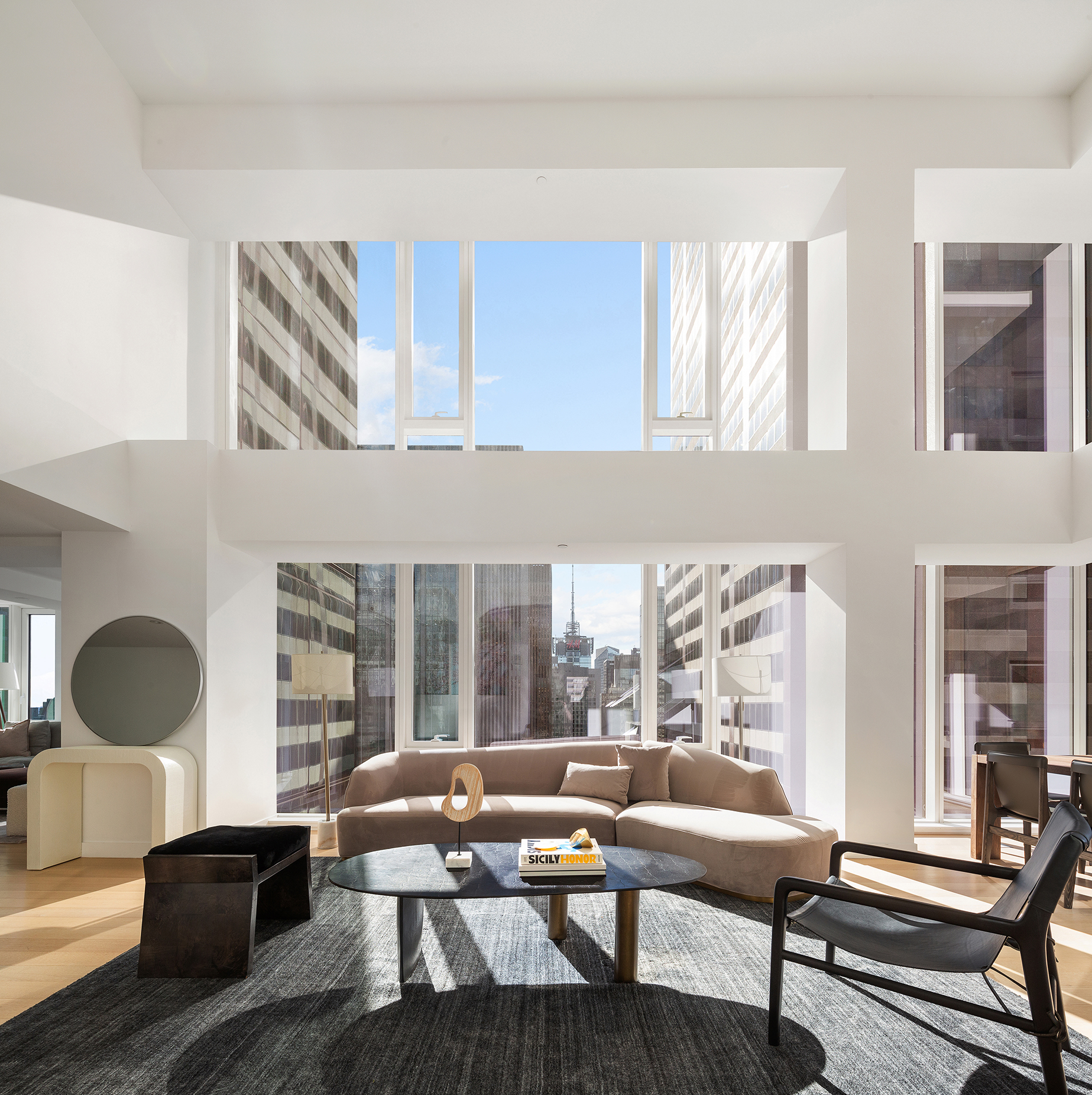 135 West 52nd Street, Unit PH3 Manhattan, NY 10019 - Photo 4 of 17 a living room with furniture and a floor to ceiling window