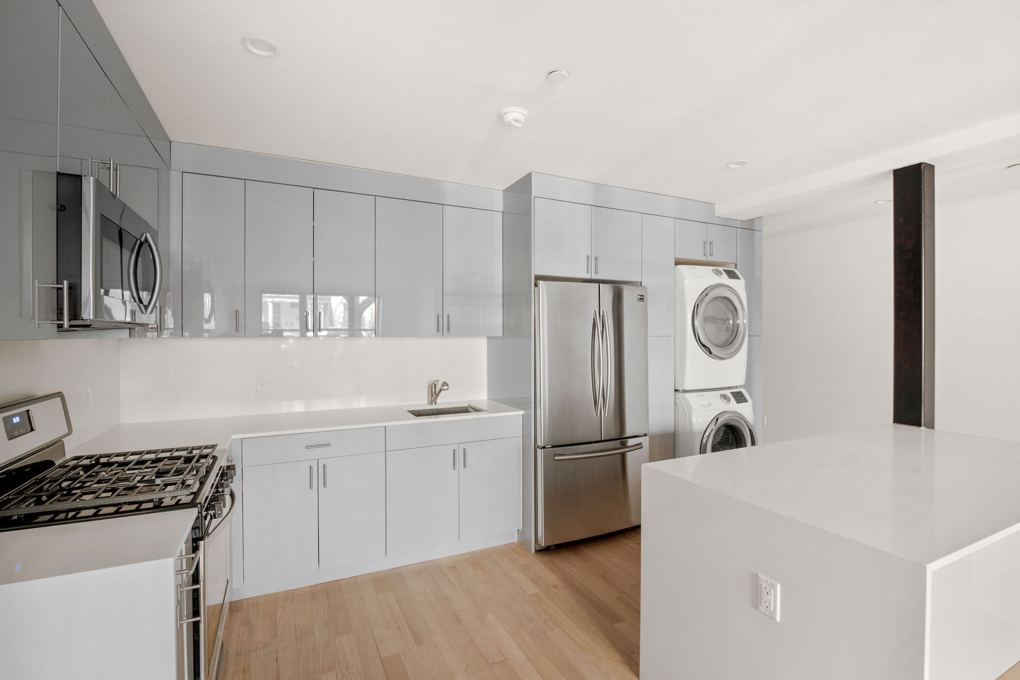 916 Greene Avenue, Unit 1 Brooklyn, NY 11221 - Photo 3 of 9 a kitchen with stainless steel appliances a refrigerator a sink a stove and white cabinets