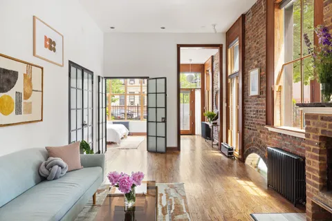 a living room with furniture and floor to ceiling windows