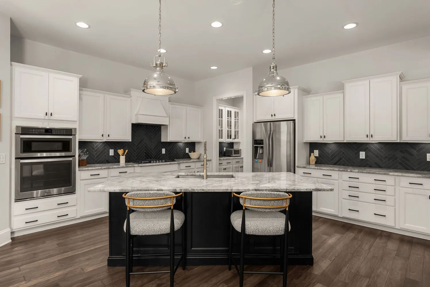 a kitchen with granite countertop a refrigerator stove and sink with wooden floor
