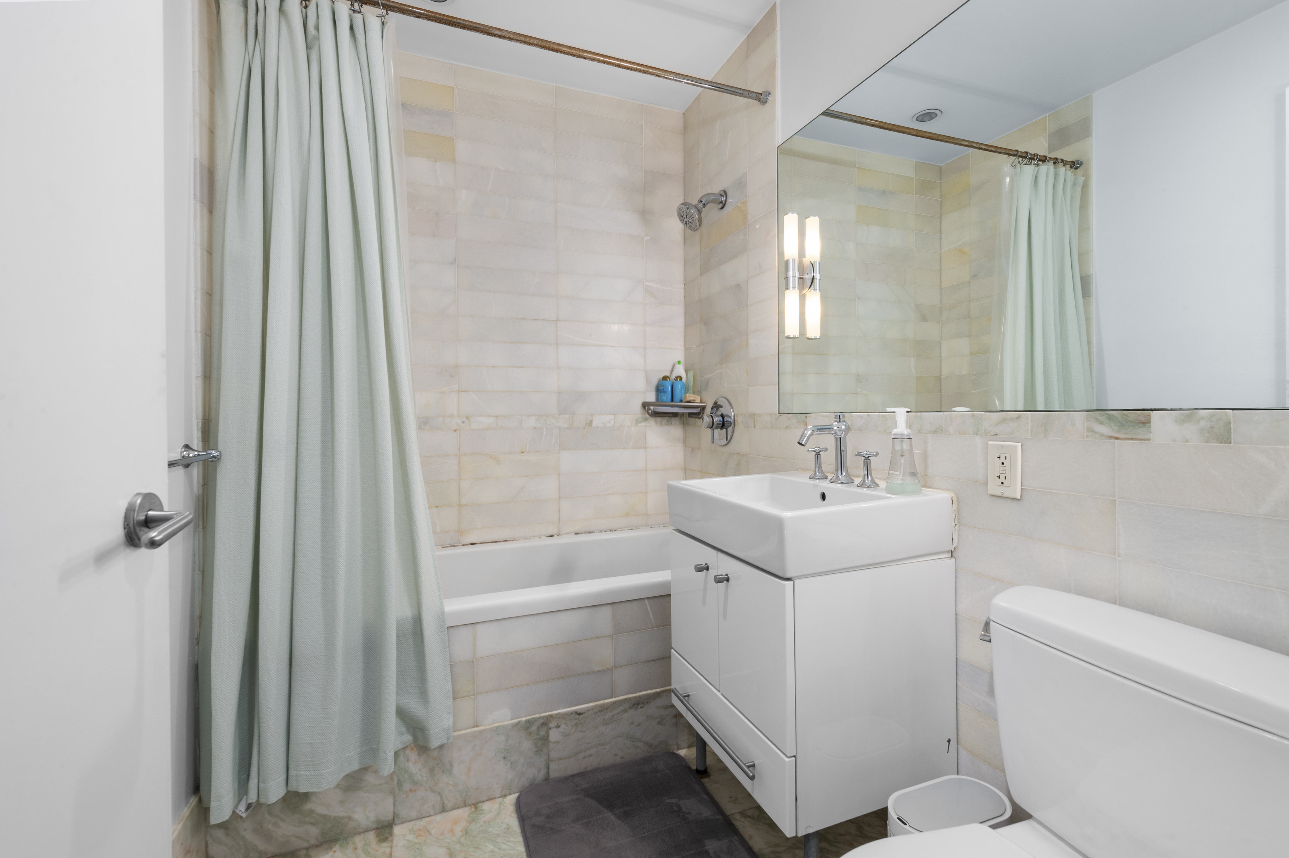 635 West 42nd Street, Unit 14K Manhattan, NY 10036 - Photo 10 of 19 a bathroom with a sink a toilet and shower