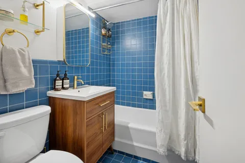 a bathroom with a sink and mirror with bathtub