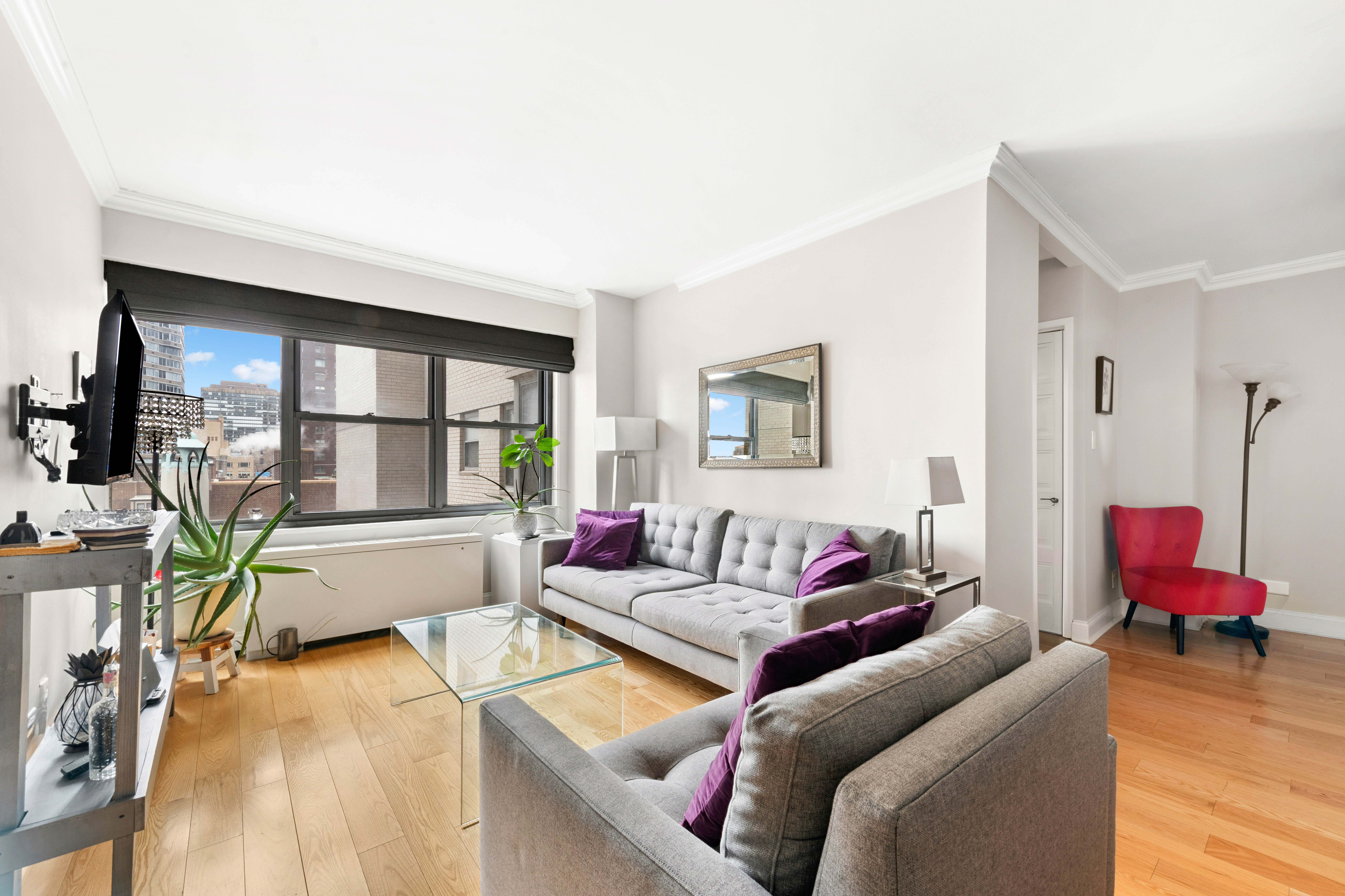 400 East 56th Street, Unit 19O Manhattan, NY 10022 - Photo 3 of 20 a living room with furniture and a large window