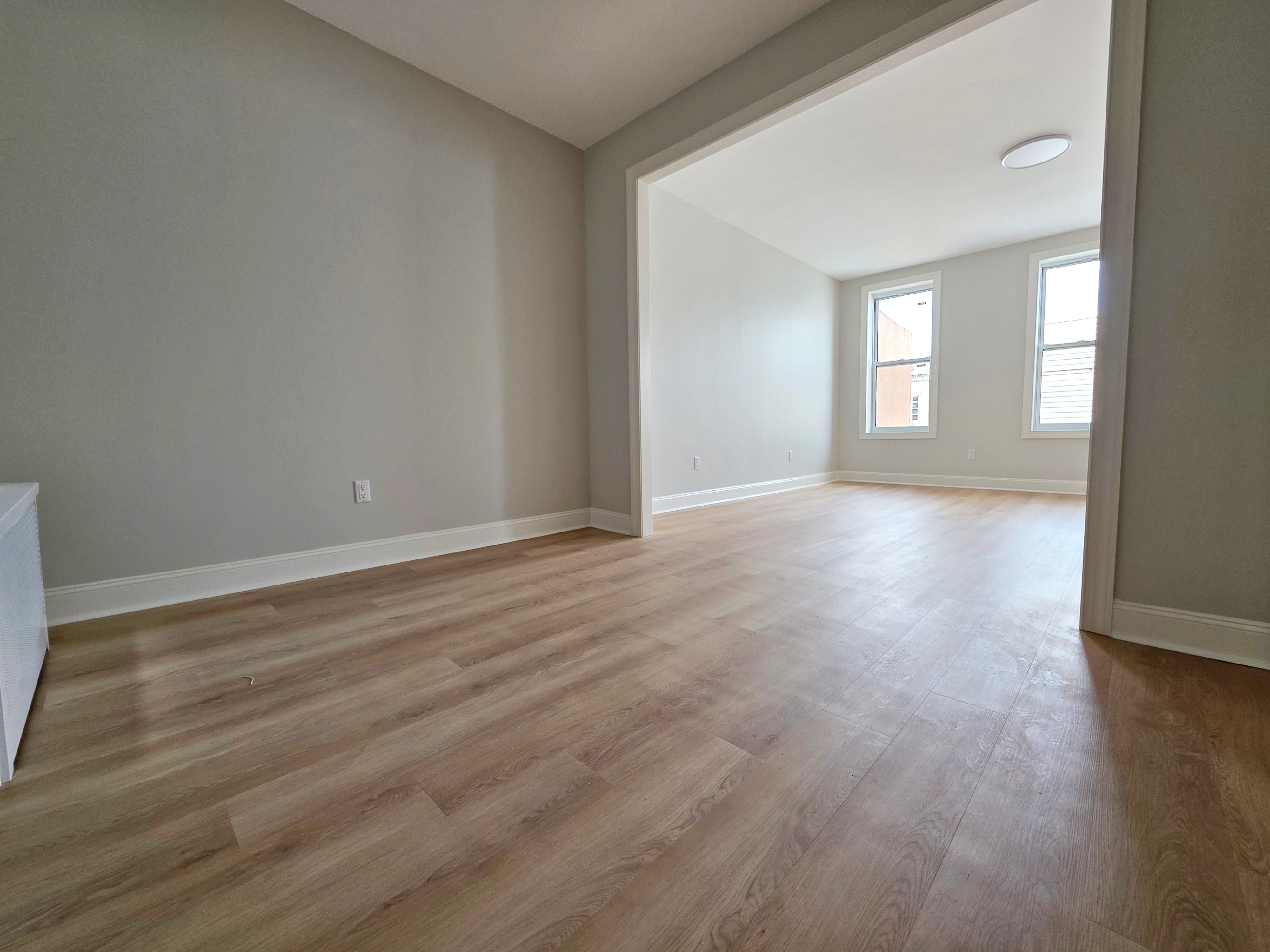 733 Metropolitan Avenue, Unit 3 Brooklyn, NY 11211 - Photo 8 of 13 a view of an empty room with wooden floor and a window