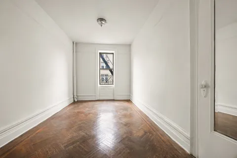 an empty room with windows and closet