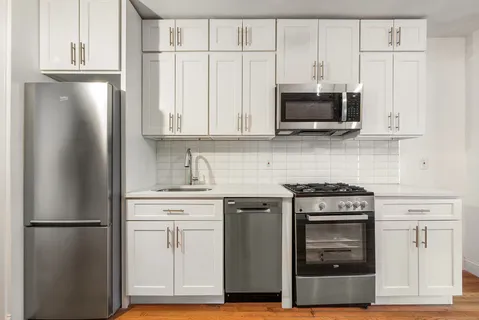 a kitchen with stainless steel appliances wooden cabinets and a stove top oven