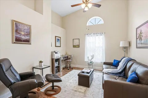 a living room with furniture chandelier and a mirror