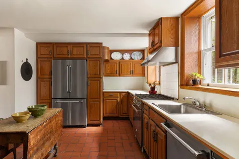 a kitchen with stainless steel appliances granite countertop a sink a stove and a refrigerator