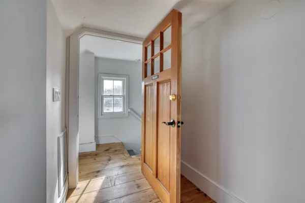 a view of a hallway with a livingroom and a bathroom with sink