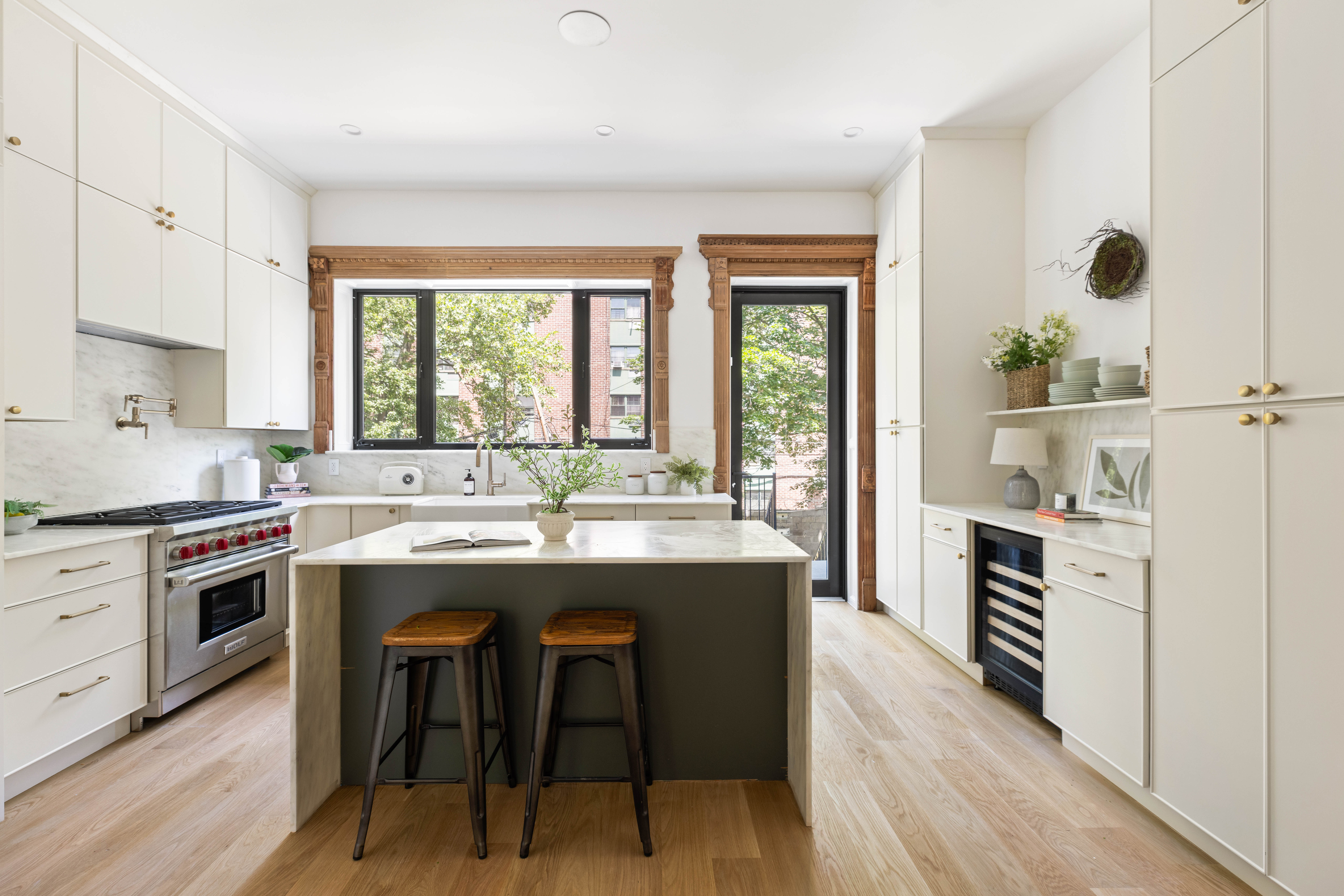 521 Monroe Street, Unit TWNHS Brooklyn, NY 11221 - Photo 5 of 17 a kitchen with kitchen island a stove a sink a dining table and chairs