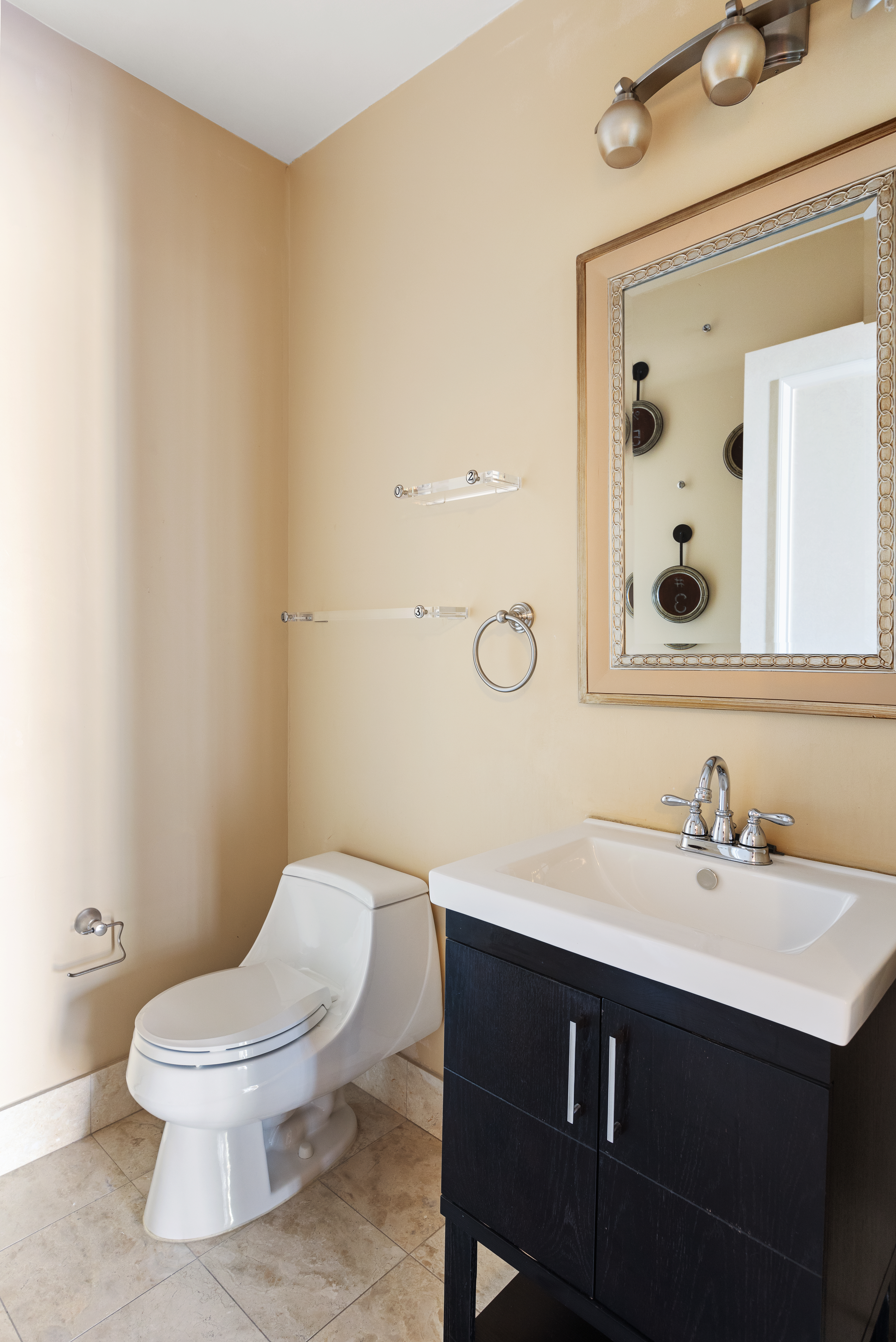 10 West Street, Unit 27B Manhattan, NY 10004 - Photo 6 of 8 a bathroom with a sink mirror and toilet