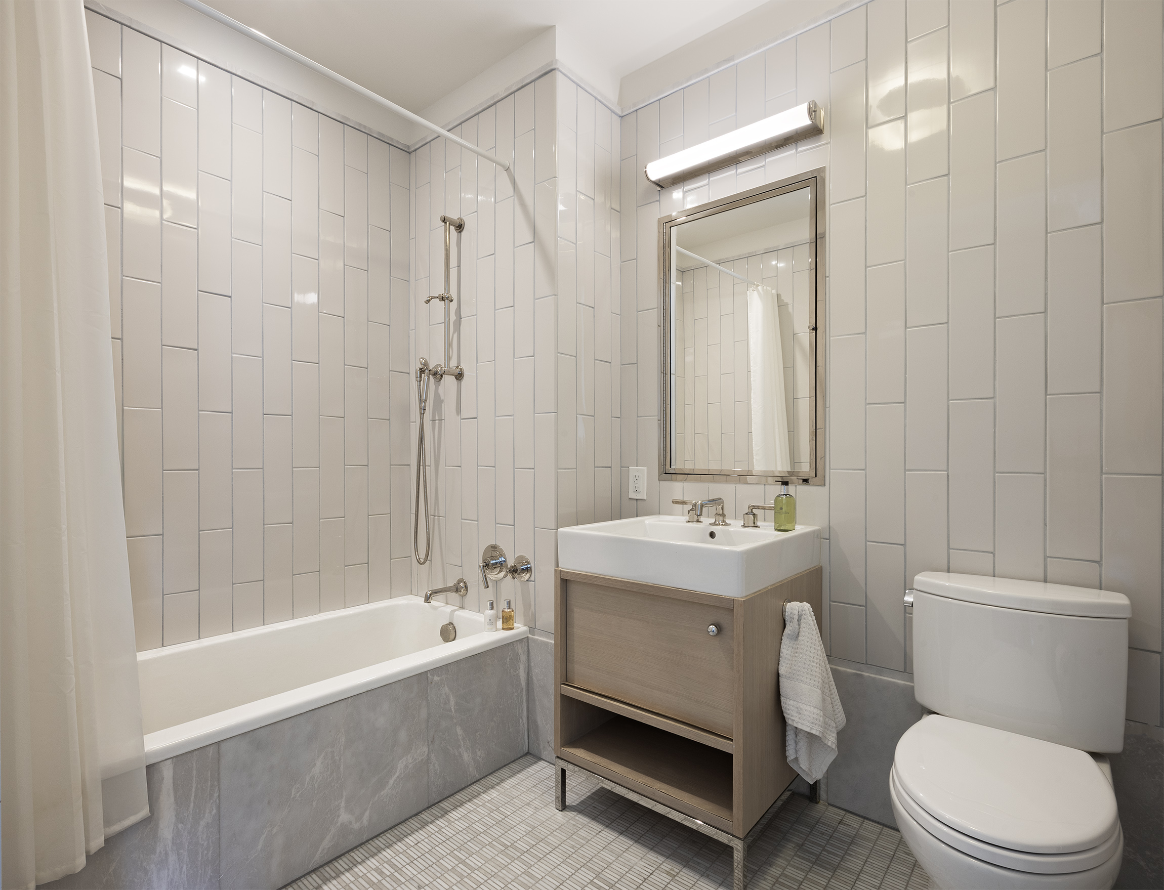 301 East 50th Street, Unit 16B Manhattan, NY 10022 - Photo 8 of 15 a bathroom with a sink a toilet and shower