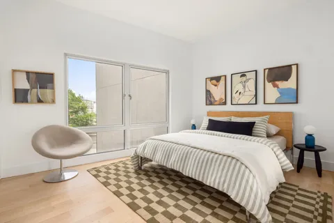 a bedroom with a bed and a painting on the wall