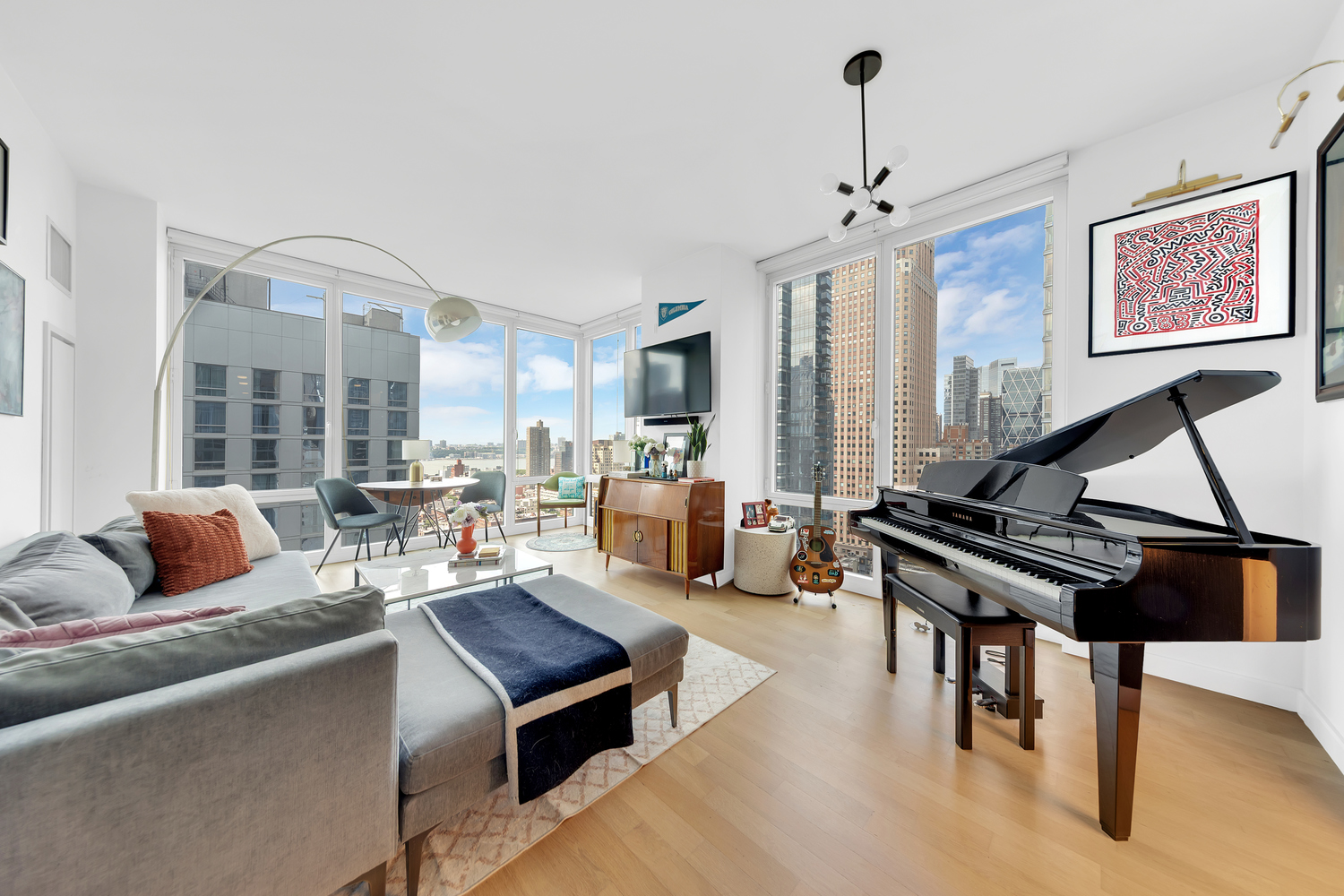 247 West 46th Street, Unit 2501 Manhattan, NY 10036 - Photo 1 of 6 a living room with furniture a rug and a chandelier
