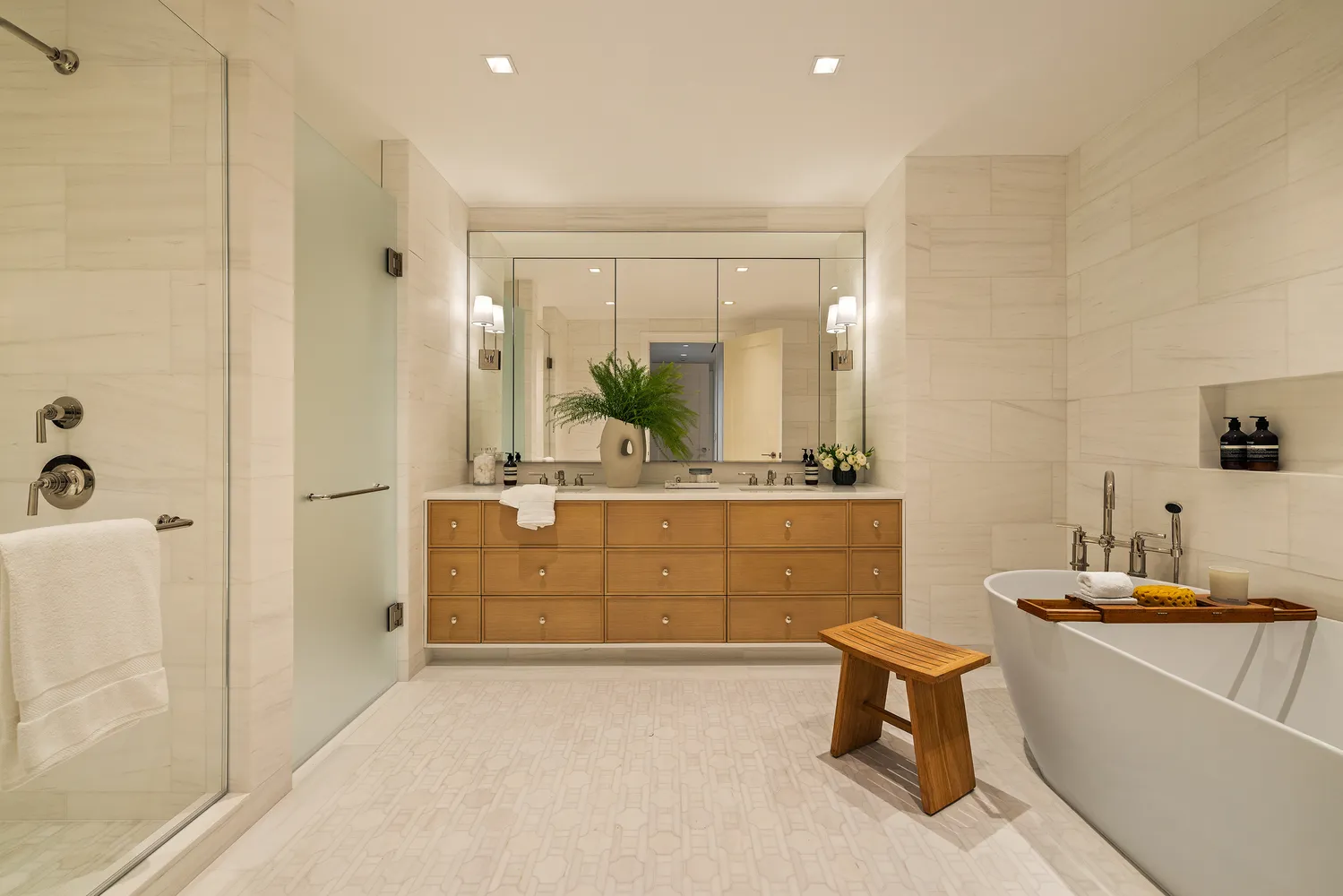 a spacious bathroom with a double vanity sink a mirror a bathtub and a shower