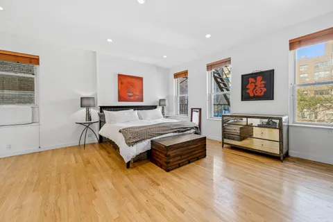a spacious bedroom with a bed and a flat screen tv