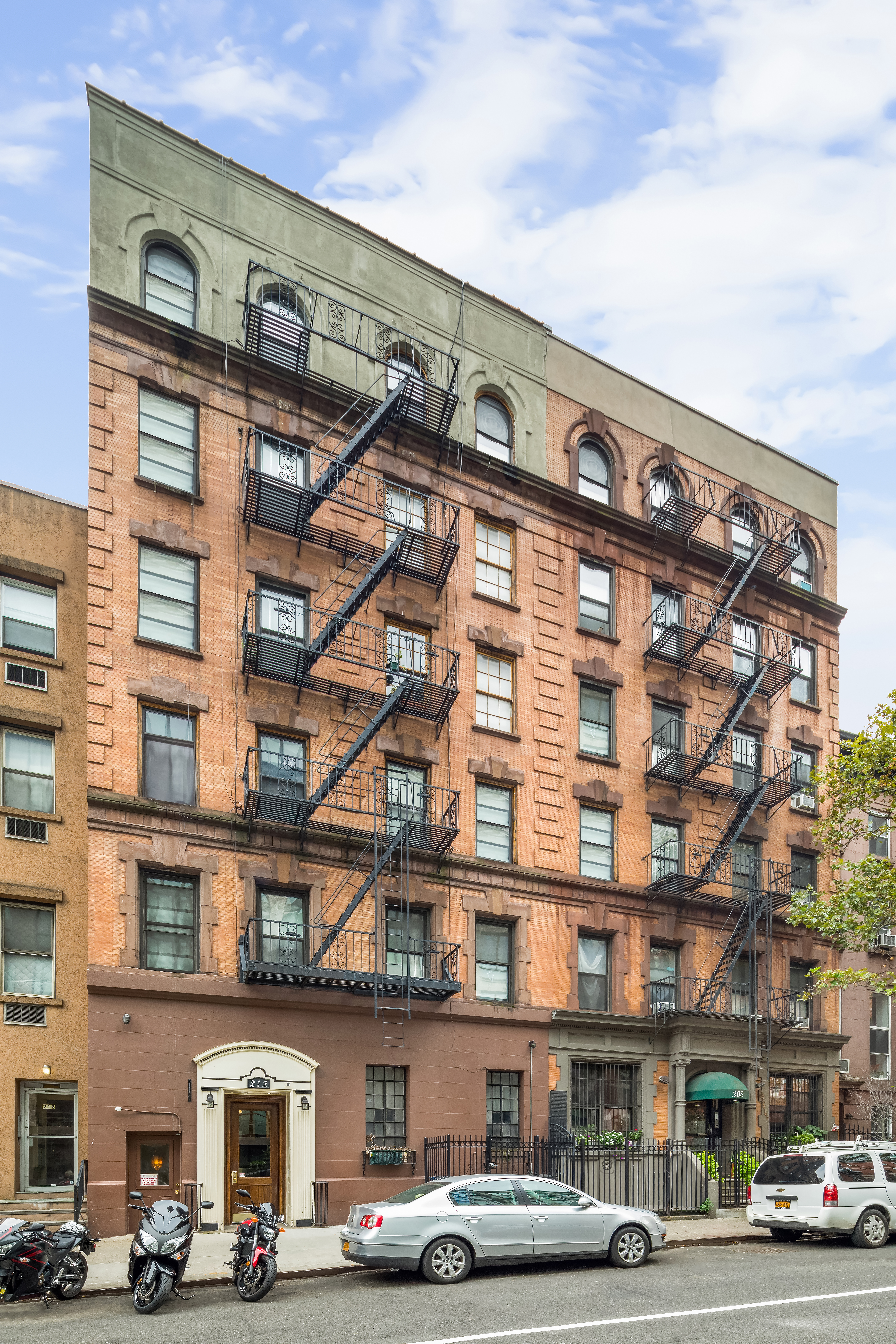 212 East 13th Street, Unit 4D Manhattan, NY 10003 - Photo 6 of 8 a front view of a building with lot of cars and trees