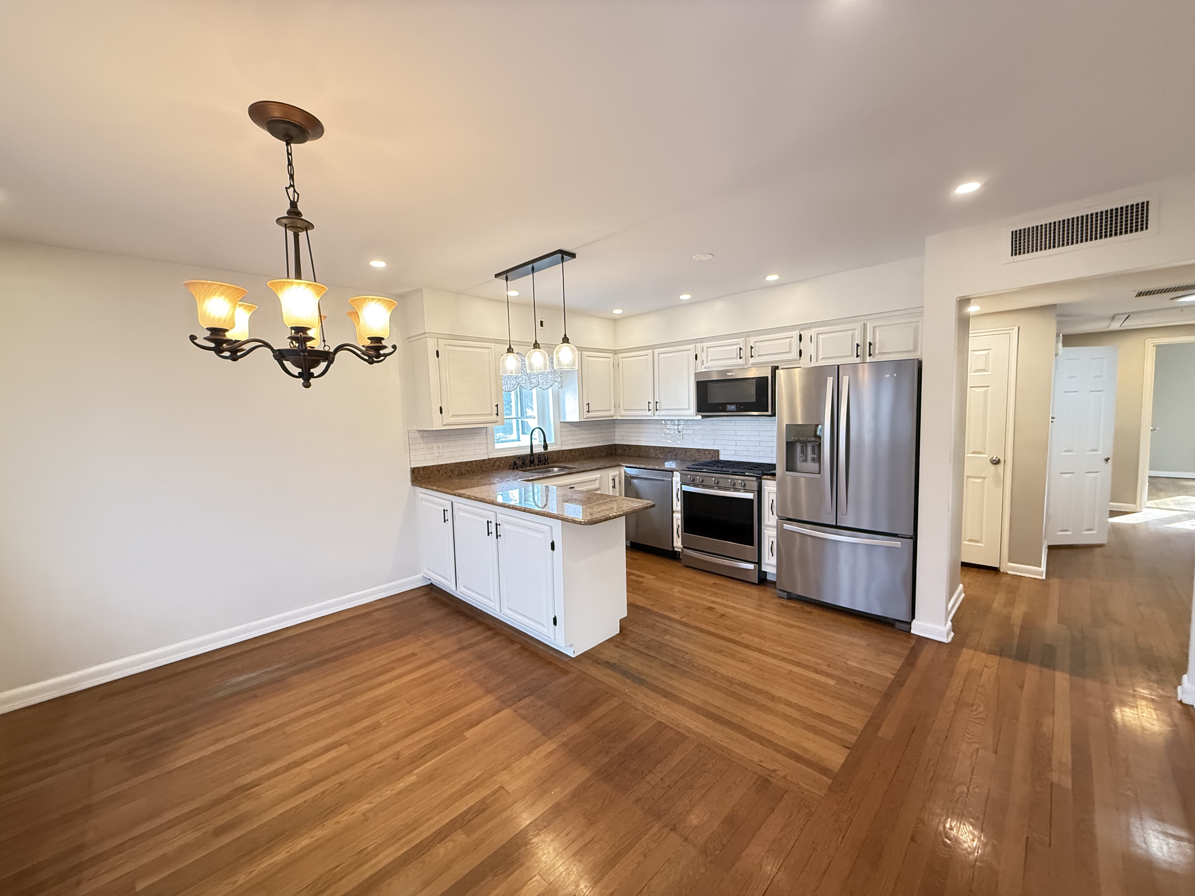 3236 Country Club Road Bronx, NY 10465 - Photo 6 of 22 a kitchen with stainless steel appliances granite countertop a refrigerator a sink dishwasher a stove and a dining table with wooden floor