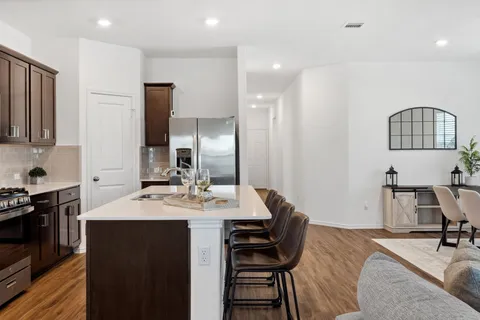a view of a kitchen with a dining table chairs and a refrigerator