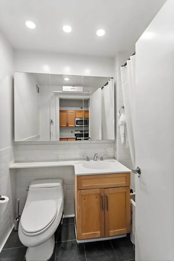 a bathroom with a sink toilet and mirror