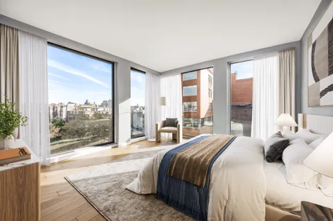 a bedroom with a large bed and a large window with outer view