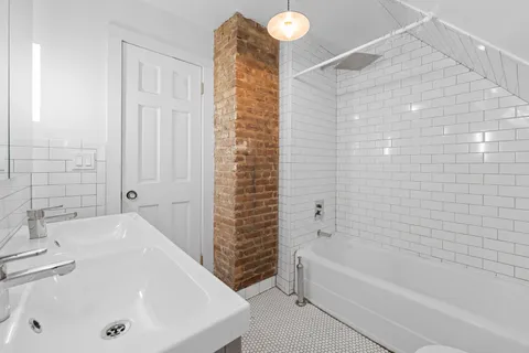 a bathroom with a tub a sink and a shower