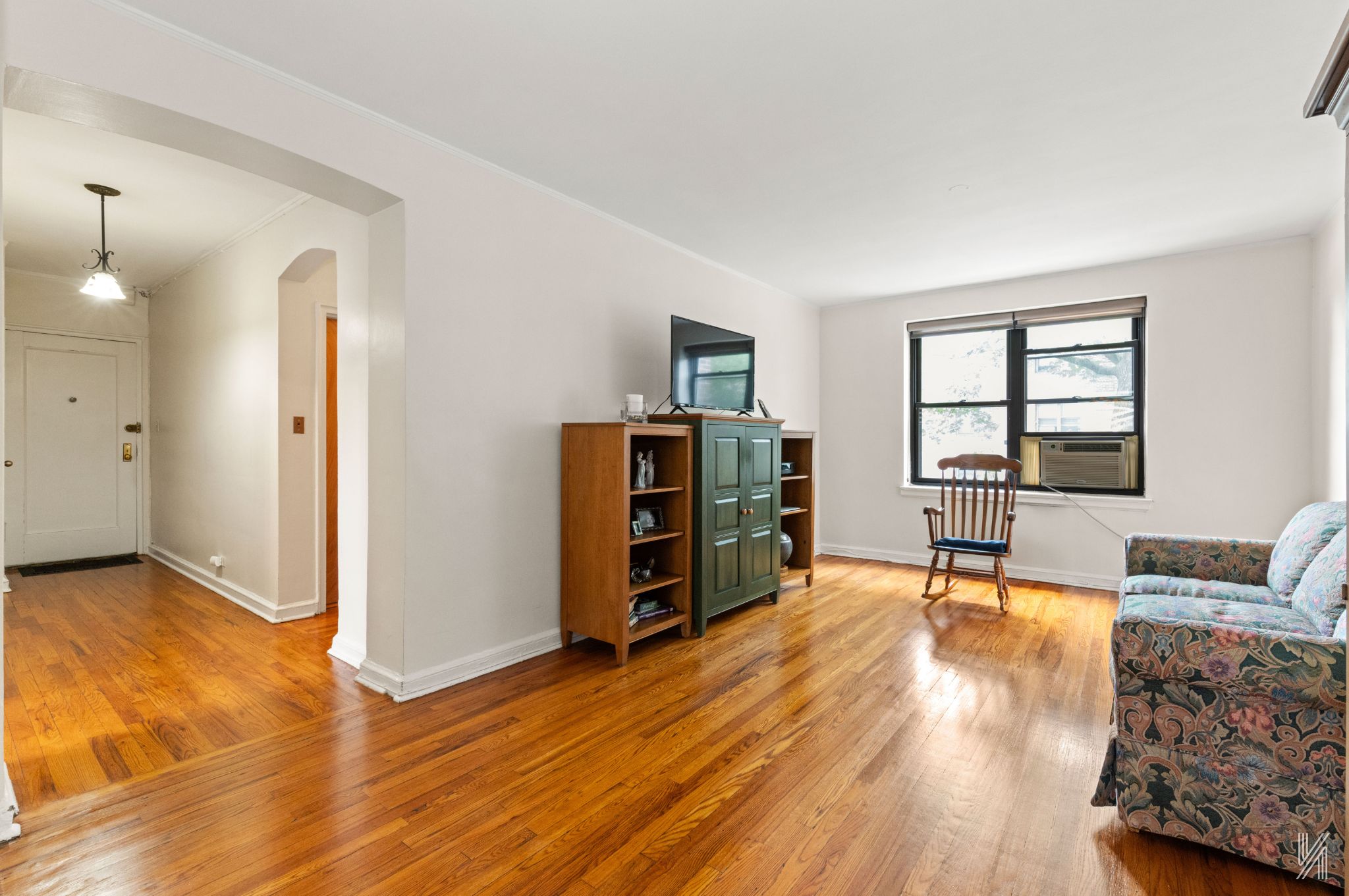 22-08 76th Street, Unit D2 Queens, NY 11370 - Photo 4 of 20 a living room with furniture and a wooden floor