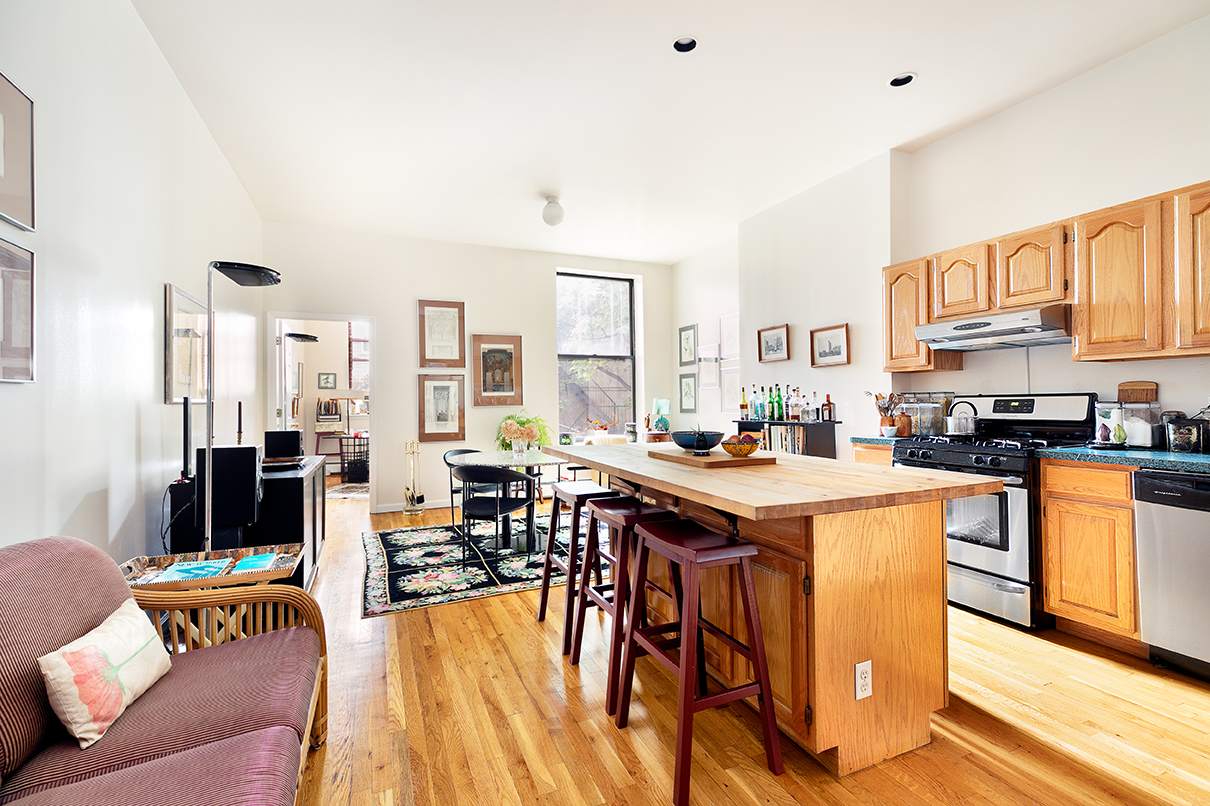 530 West 148th Street Manhattan, NY 10031 - Photo 5 of 14 a kitchen with stainless steel appliances granite countertop a table and chairs