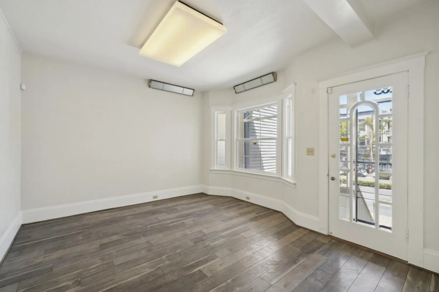 a view of a room with wooden floor and a ceiling fan