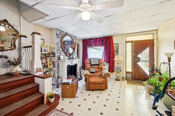 a living room with furniture a fireplace and a chandelier
