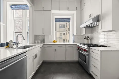 a kitchen with stainless steel appliances granite countertop a sink stove and cabinets