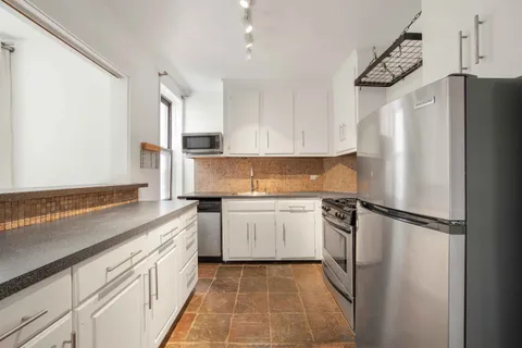 a kitchen with a refrigerator sink and cabinets