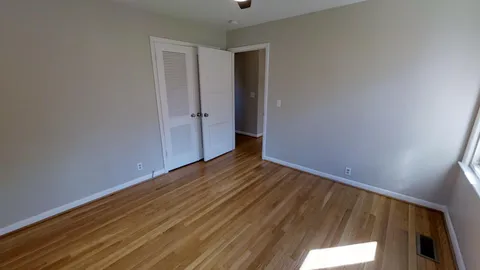 a view of a room with wooden floor and bathroom