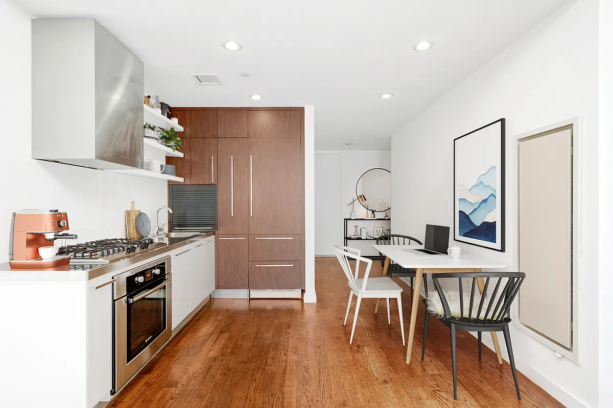 133 West 22nd Street, Unit 6A Manhattan, NY 10011 - Photo 2 of 9 a kitchen with a table chairs a sink dishwasher stove and cabinets with wooden floor