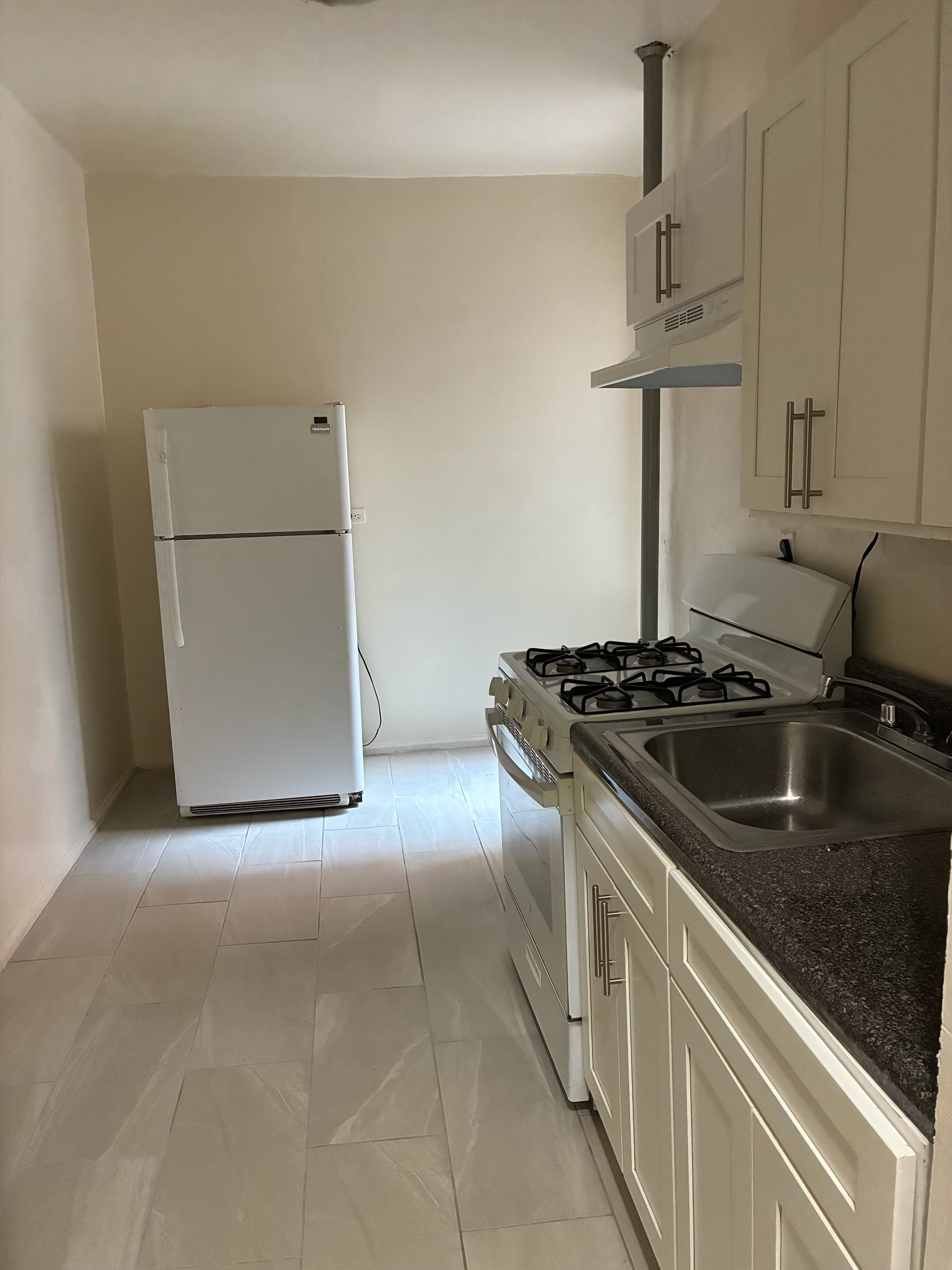 2755 Reservoir Avenue, Unit 1F Bronx, NY 10468 - Photo 5 of 5 a kitchen with stainless steel appliances granite countertop a sink stove and refrigerator