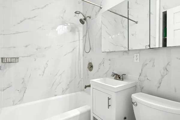 a bathroom with a sink a toilet and shower