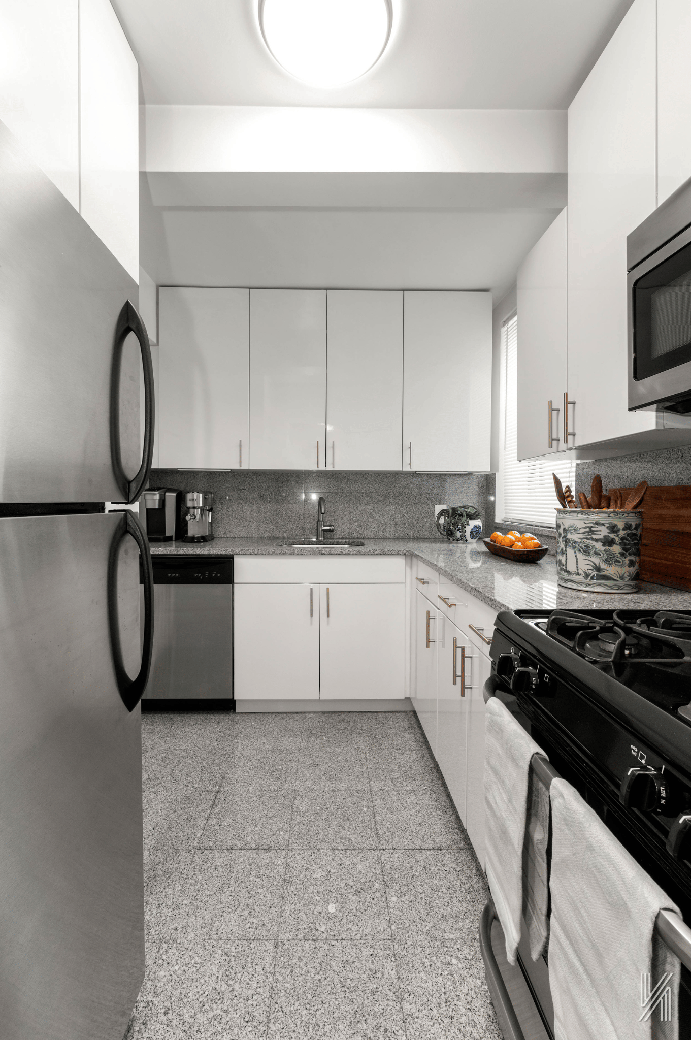 22-40 80th Street, Unit 3B Queens, NY 11370 - Photo 9 of 14 a white kitchen with granite countertop a sink a stove top oven and white stainless steel appliances