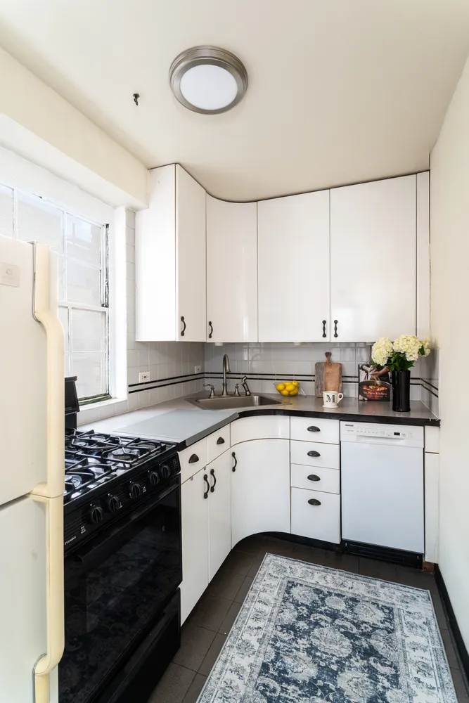 a kitchen with granite countertop a stove sink and cabinets