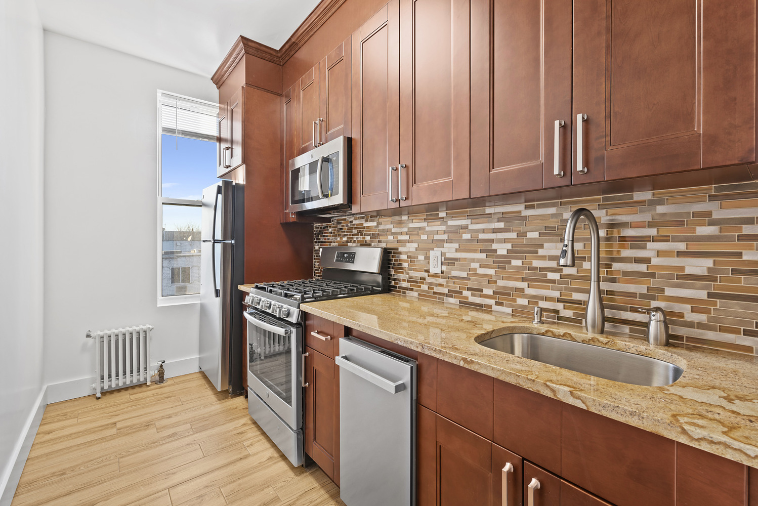 1275 Jefferson Avenue, Unit 3 Brooklyn, NY 11221 - Photo 5 of 6 a kitchen with stainless steel appliances granite countertop a sink stove and refrigerator