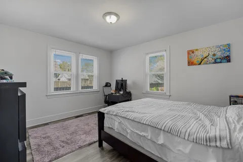 a bedroom with a bed and wooden floor