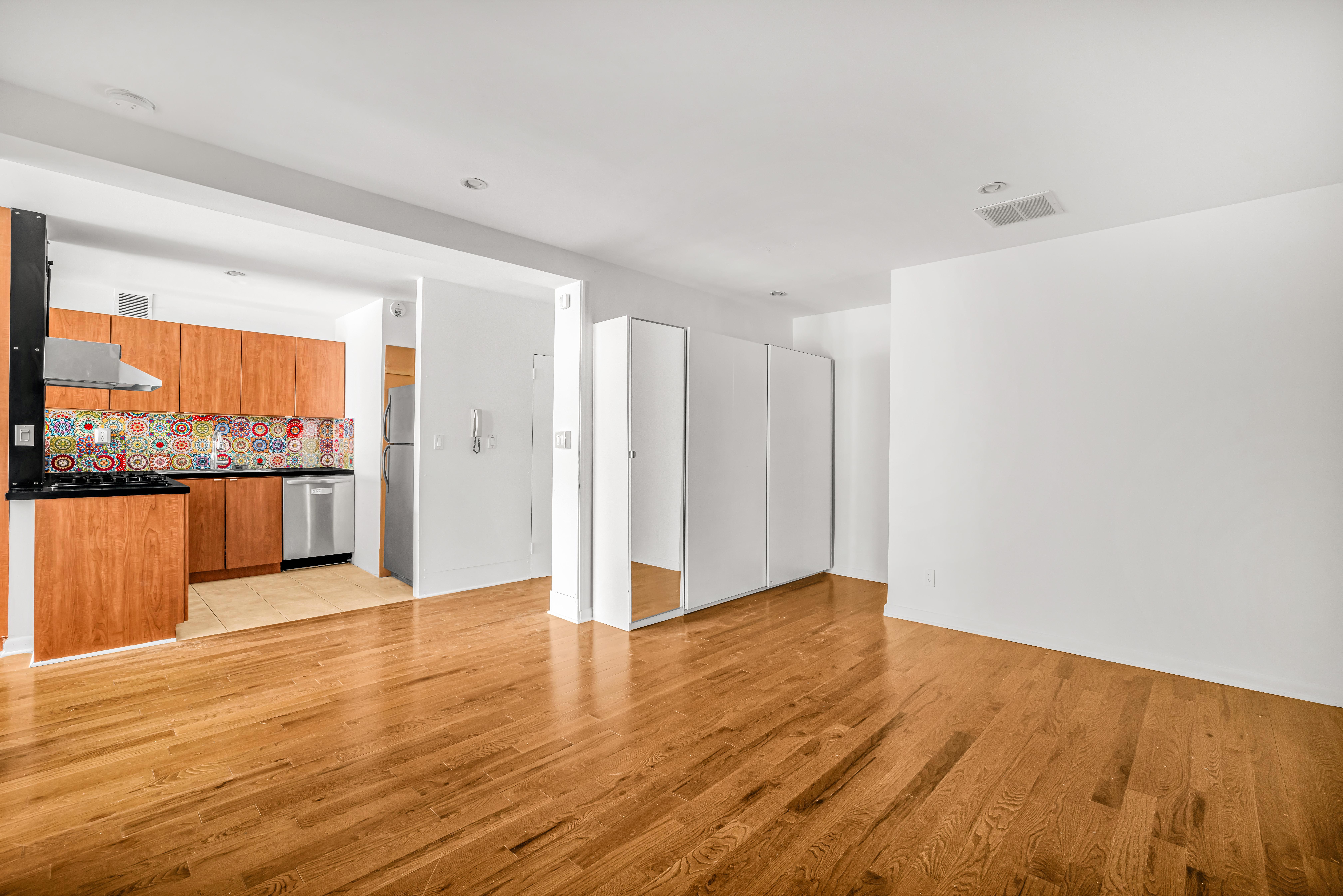 44 East 12th Street, Unit 8E Manhattan, NY 10003 - Photo 4 of 7 a view of an empty room with wooden floor and a window