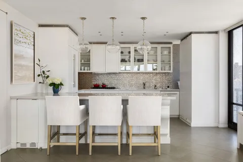 a kitchen with granite countertop white cabinets and chairs