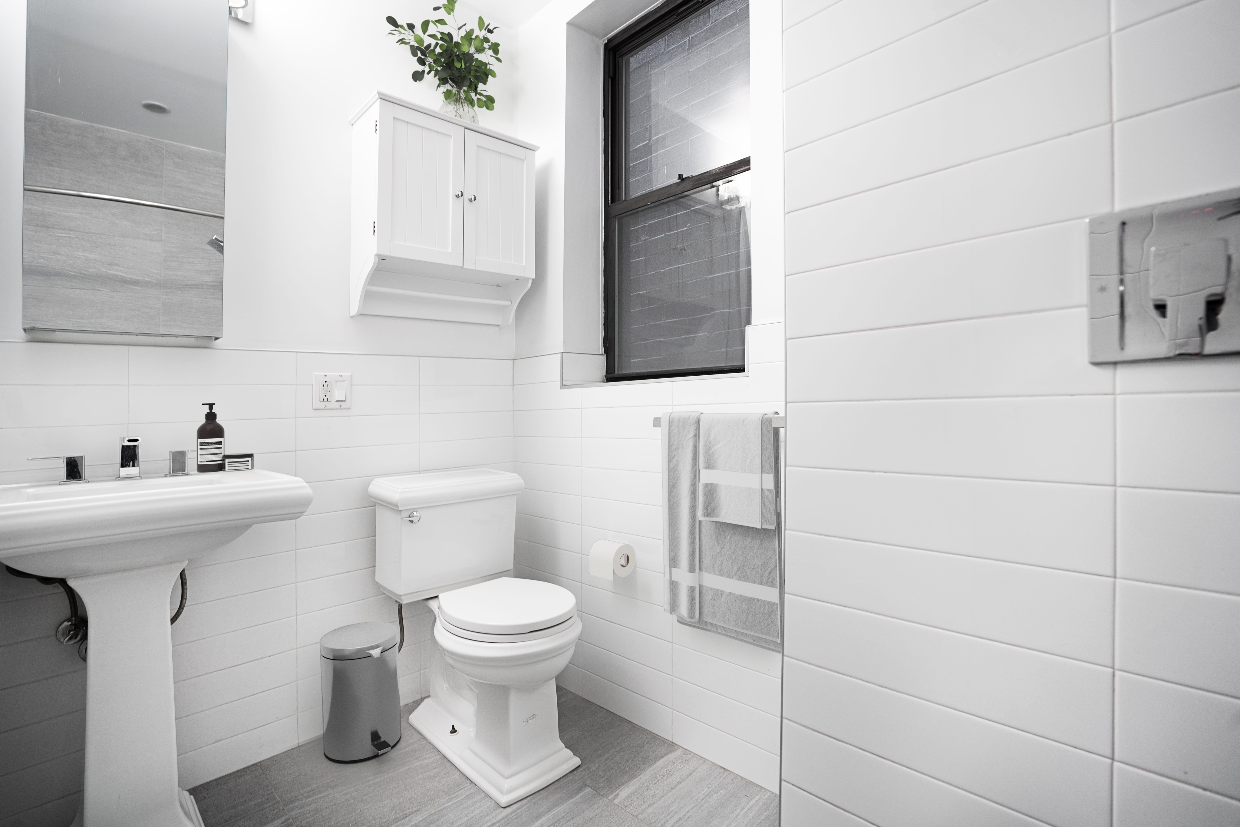 150 West 84th Street, Unit 1B Manhattan, NY 10024 - Photo 9 of 10 a bathroom with a toilet sink and mirror