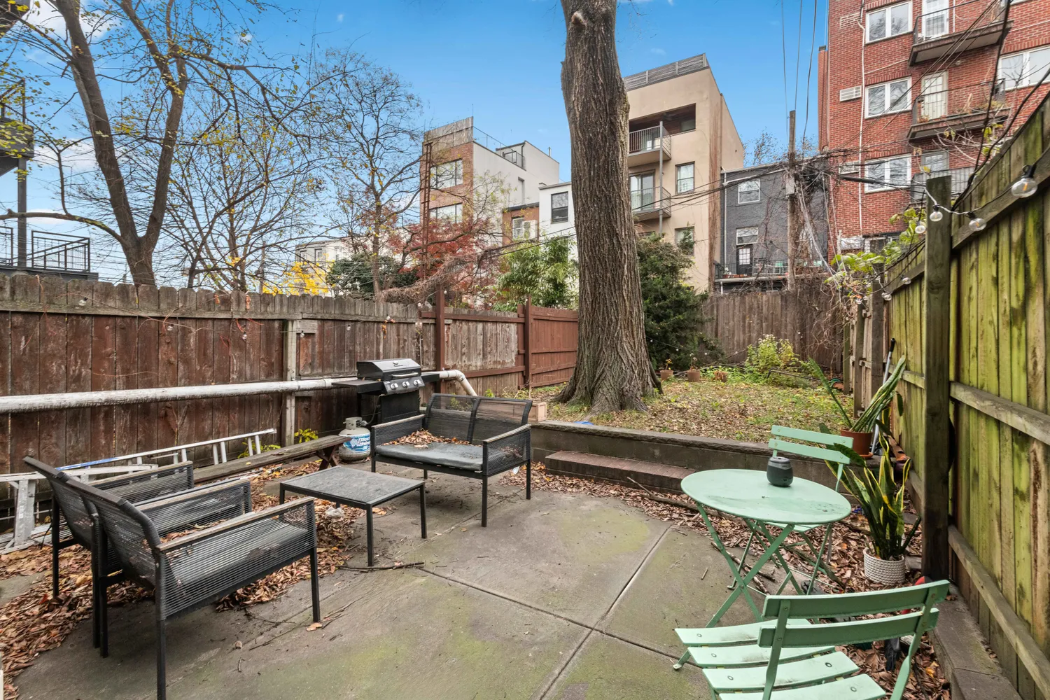 a backyard of a house with barbeque oven table and chairs