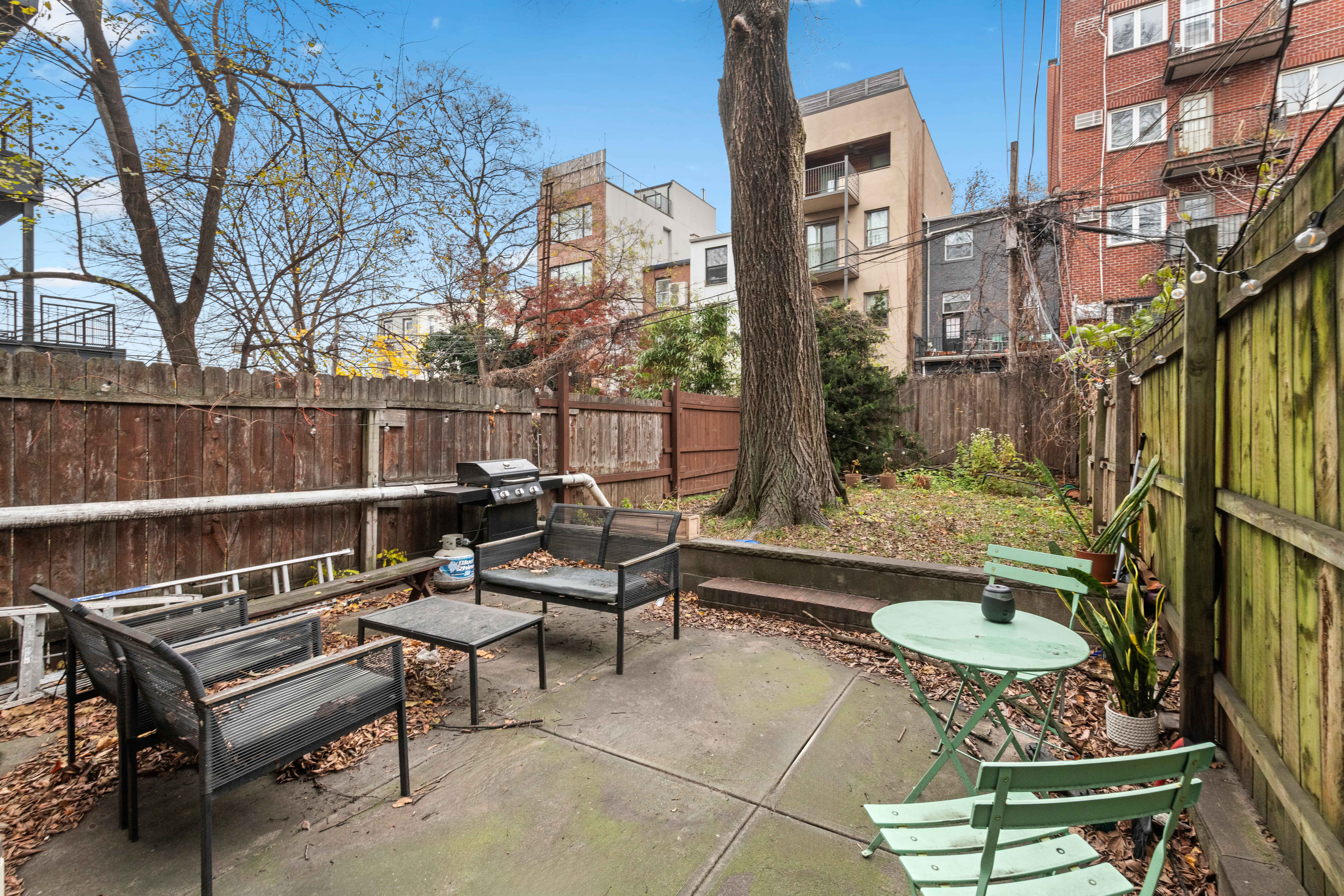 a backyard of a house with barbeque oven table and chairs