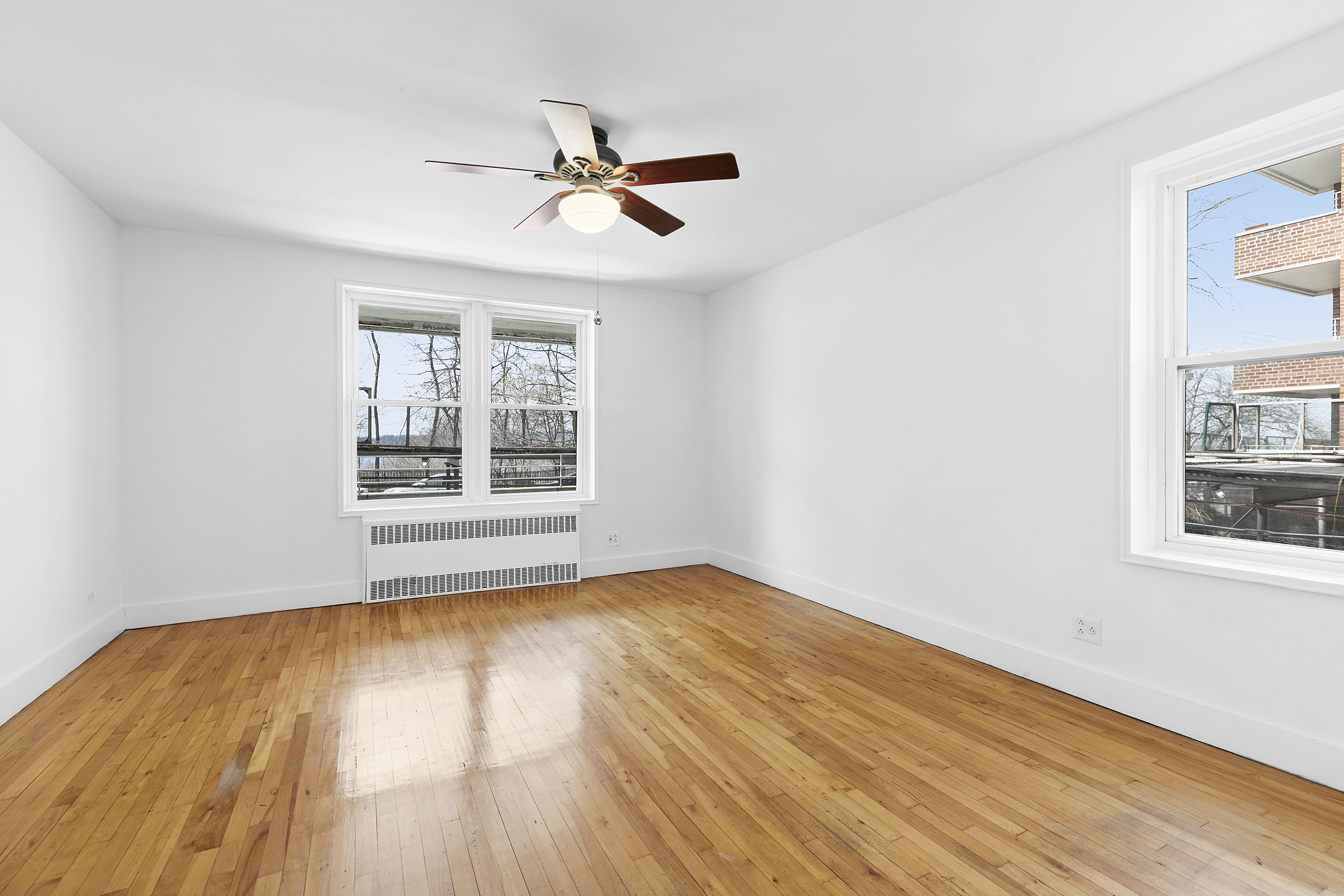 9801 Shore Road, Unit 1K Brooklyn, NY 11209 - Photo 6 of 11 a view of an empty room with wooden floor and a window